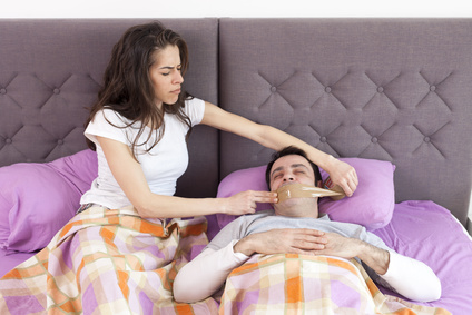 Woman taping snoring mouth.jpg